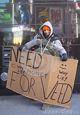 Unidentified man with sign asking for money to buy weed on Broadway during Super Bowl XLVIII week in Manhattan Editorial Stock Photo