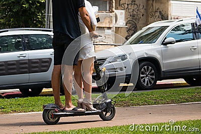 Unidentified Man and women riding an electric scooter Editorial Stock Photo