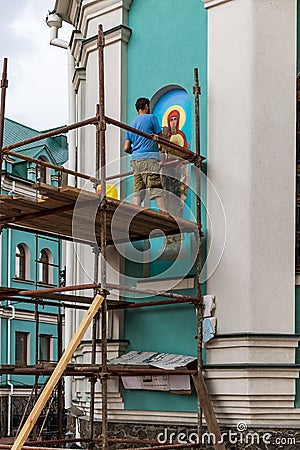 An unidentified Muralist repair a painting on the wall of an Orthodox church. Editorial Stock Photo