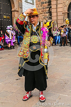 Unidentified participant in traditional clothes celebratesreligious festivity in front of the Cathedral of Santo Domingo in Cusco Editorial Stock Photo