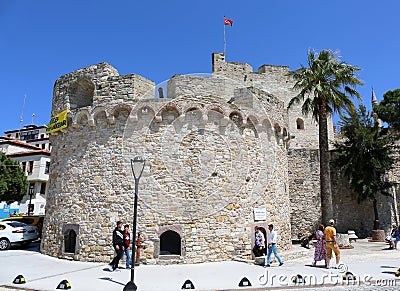 Unidentified people walking by the Historic Cesme Castle in Cesme, Turkey. Editorial Stock Photo