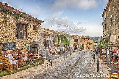Unidentified poople eating in street restaurant, Architecture of Ramatuelle city in French Riviera, France Editorial Stock Photo