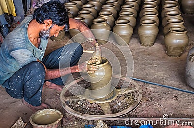 Unidentified potter making clay water pots on pottery wheel. Editorial Stock Photo