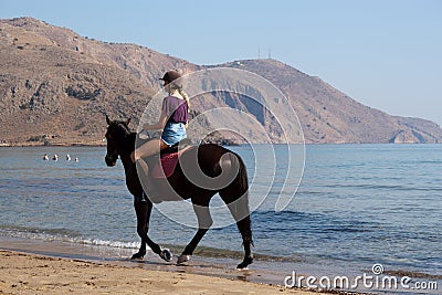Unidentified rider on a horse on the beach Editorial Stock Photo