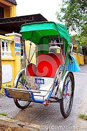 An unidentified service cyclo rider passing an ancient house Editorial Stock Photo