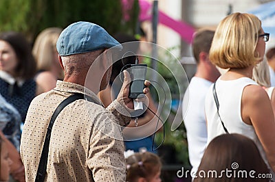 Unidentified spectator filming a concert Editorial Stock Photo