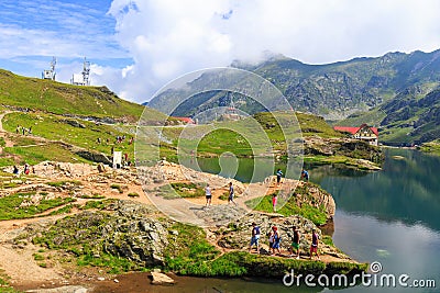 Unidentified tourists enjoy the sights of Balea Lake at 2,034 m altitude on July 21 Editorial Stock Photo