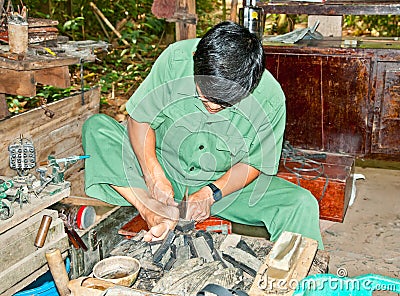 Unidentified vietnamese makes shoes from old truck tires in Cu C Editorial Stock Photo