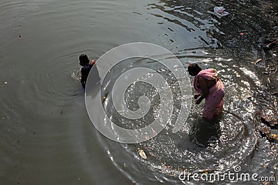 Woman takes holy dip in the Adi Ganga river near Kalighat temple Editorial Stock Photo