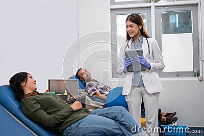 Uniformed female doctor carrying a tablet chatting with a patient Stock Photo