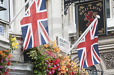 2 Union Jack flags and a pub sign in London Editorial Stock Photo