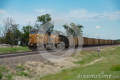 Union Pacific lashup with locomotives 6814 and 5468 smokes and steams westbound with empty coal hoppers Editorial Stock Photo