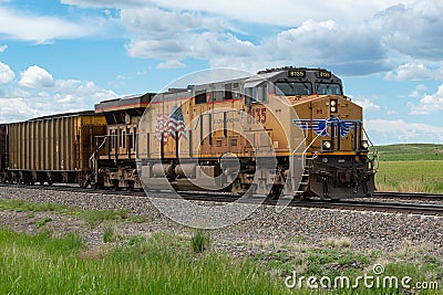 Union Pacific locomotive 8135 heads eastbound with a train with coal loaded hoppers with helper Union Pacific diesel locomotive Editorial Stock Photo