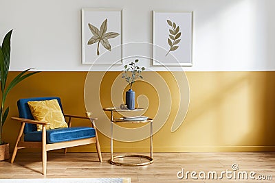 Unique living room in modern style interior with design armchair, elegant gold coffee table, mock up poster frames, flowers. Stock Photo