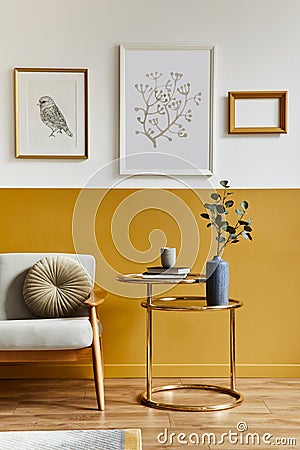 Unique living room in modern style interior with design sofa, elegant gold coffee table, mock up poster frames, flowers in vase. Stock Photo