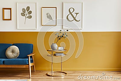 Unique living room in modern style interior with design sofa, elegant gold coffee table, mock up poster frames, flowers in vase. Stock Photo