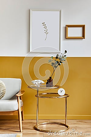 Unique living room in modern style interior with design sofa, elegant gold coffee table, mock up poster frames, flowers in vase. Stock Photo