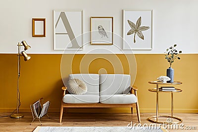 Unique living room in modern style interior with design sofa, elegant gold coffee table, mock up poster frames, flowers in vase. Stock Photo