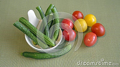 Still life of mini vegetables on a green background. Stock Photo