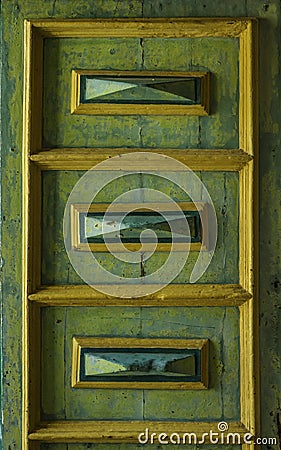Unique old decorated detail of wooden door in faded green historic from Sicily Stock Photo