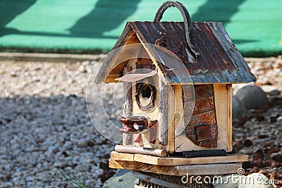 unique rustic hand made tin roof birdhouse rock ground Stock Photo