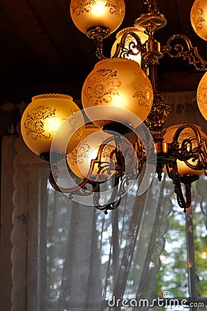 Unique vintage chandelier or hanging ceiling lamp with many light bulbs. Metallic intricate frame with many round glass lampshades Stock Photo