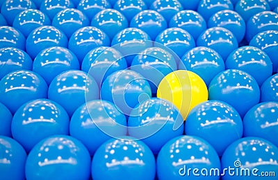 Unique yellow ball among blue balls Stock Photo