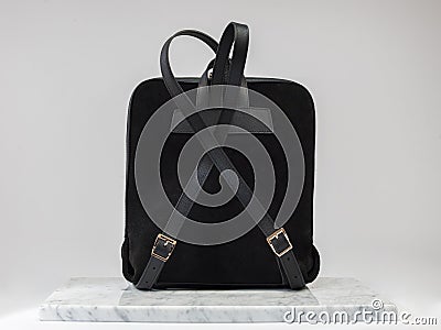 Luxury suet backbag. Luxury black leather and suet backpack on white background, on marble floor. Stock Photo