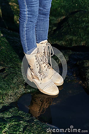 Unisex jeans and beige khaki boots with laces on green grass nature background Stock Photo