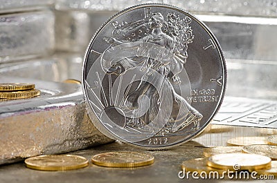 United States Silver Eagle with Gold coins & silver bars in background Stock Photo