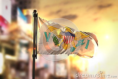 United States Virgin Islands Flag Against City Blurred Background At Sunrise Backlight Stock Photo