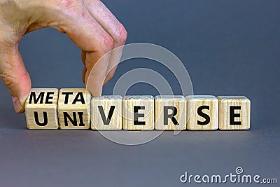 Universe or metaverse symbol. Businessman turns wooden cubes and changes the word universe to metaverse. Beautiful grey table grey Stock Photo