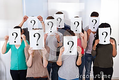 University students holding question mark signs Stock Photo