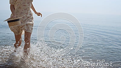 Unknown carefree lady running on sea waves in slow motion. Slim woman legs Stock Photo