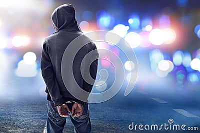 Unknown hacker in handcuffs on the street Stock Photo