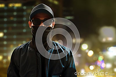 Unknown hacker standing on city background Stock Photo