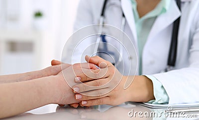 Hand of a doctor woman reassuring to female patient, close-up. Medical ethics and trust concept Stock Photo