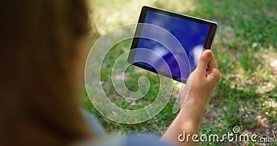 Unknown hands holding tablet on nature. Unrecognizable man have gadget on picnic Stock Photo