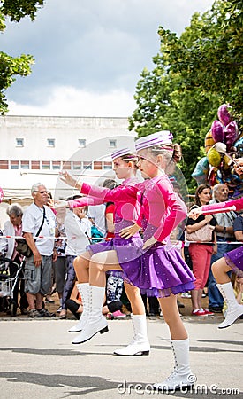 Unknown junior majorettes in pink and violet costumes with batons Editorial Stock Photo