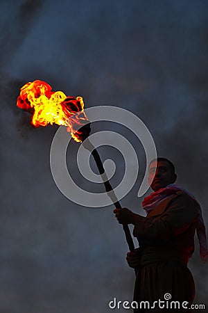 An unknown man holds a burning torch during the Nowruz / Novruz celebration near the city of Akre in Kurdish Iraq, a local traditi Editorial Stock Photo