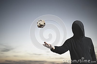 Unknown man throws a dice in the air, a sign of fate and luck Stock Photo