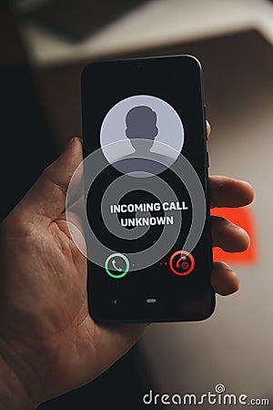 Unknown number calling in the middle of the night. Phone call from stranger. Person holding mobile and smartphone home Stock Photo