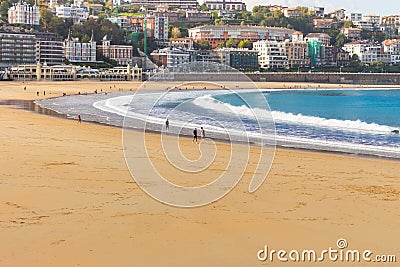 Unknown people walking on the beach called La Concha. Tourists in bay of Biscay in San Sebastian in autumn. Wide aerial beach. Editorial Stock Photo