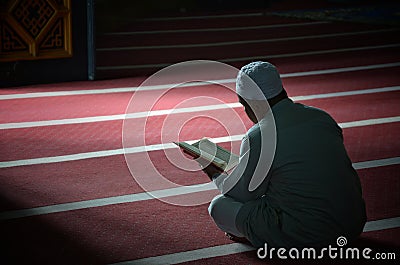 An unknown person is reading the Koran with solemnity in a mosque Editorial Stock Photo
