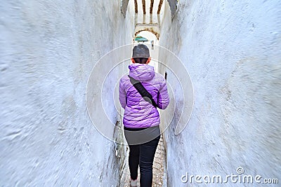 Unknown young woman walking in the old narrow street of Tetouan Medina quarter Editorial Stock Photo