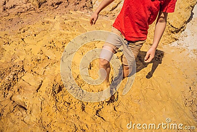 Unlucky person standing in natural quicksand river, clay sediments, sinking, drowning quick sand, stuck in the soil Stock Photo