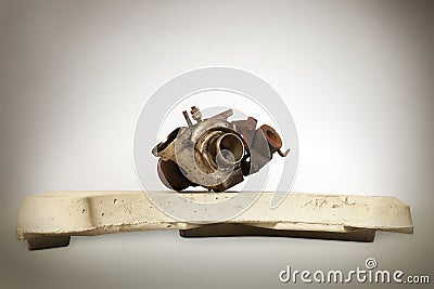 Unmounted turbocharger laying on concrete washing machine weight Stock Photo