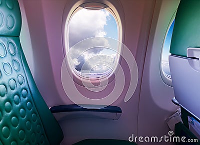 Unoccupied seat near the window in a plane with clouds Stock Photo