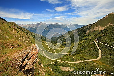 Unpaved road in the valley in Alps, italy. Stock Photo