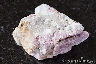 Unpolished pink Tourmaline in feldspar on black Stock Photo